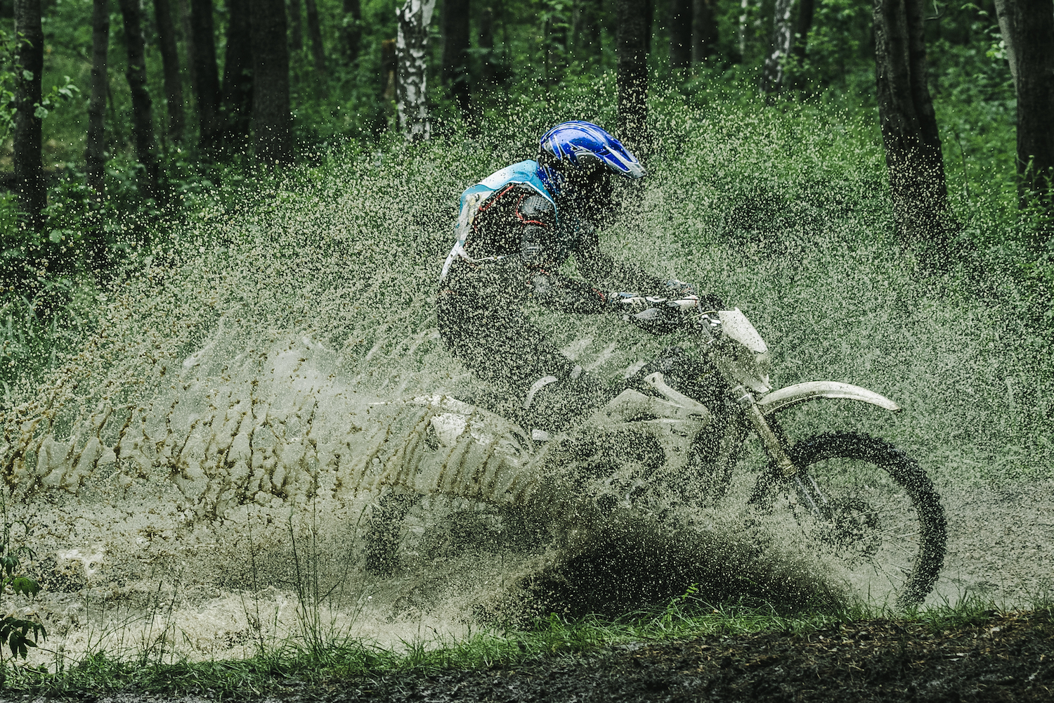 Motocross driver under the spray of mud